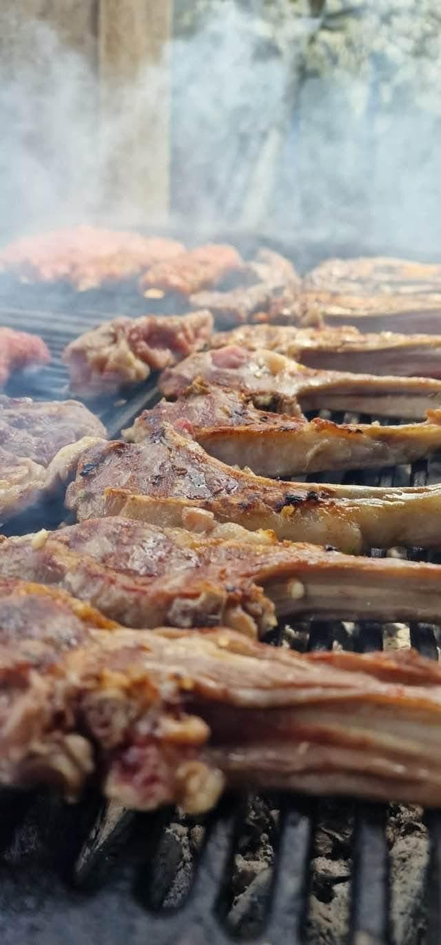 Carne pusă la grătar, pe jar, cu fum ridicându-se