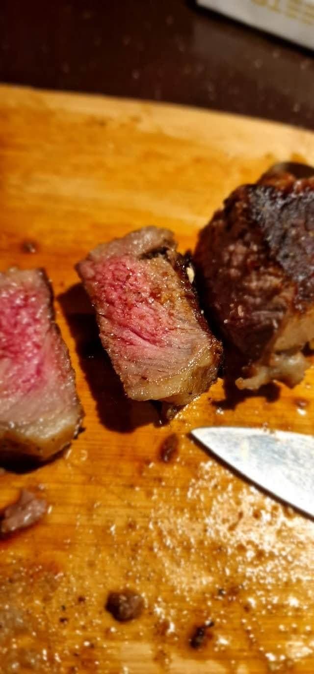 Ceafă de porc feliată pe tocător de lemn