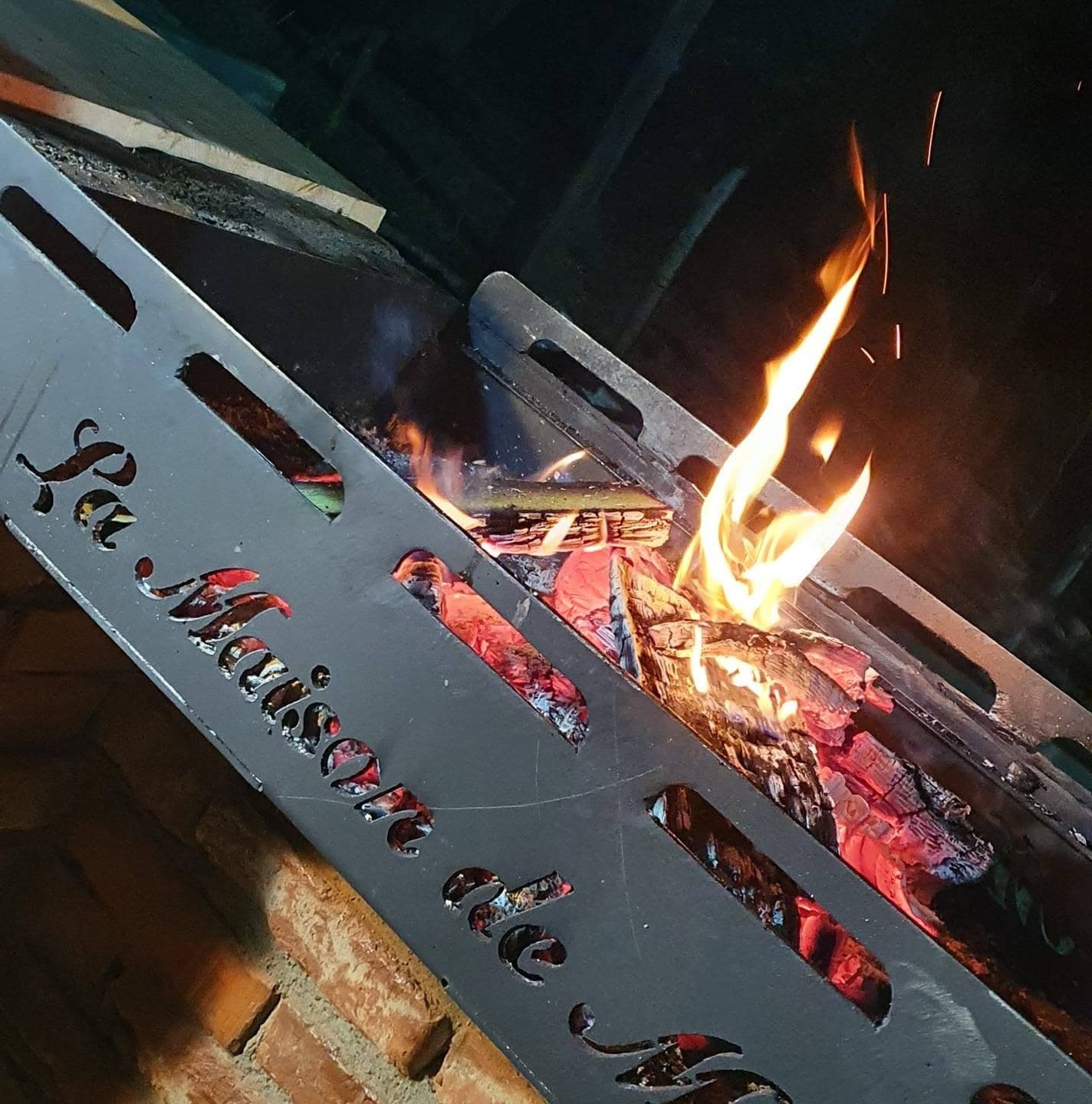 Jar și flacără în grătarul cu numele La Maison de Moise gravat în plită